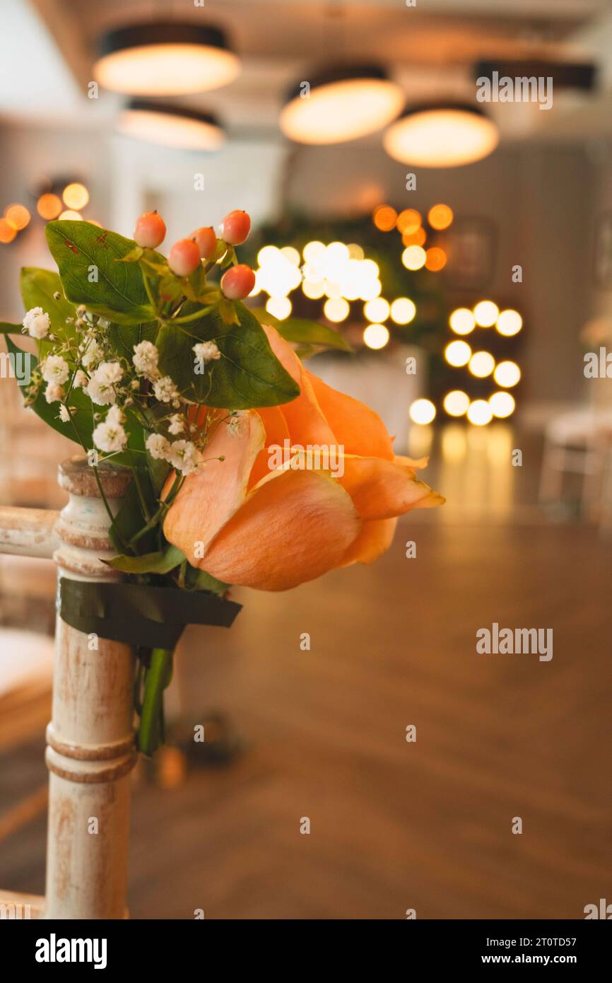 Hochzeit Stuhl Blumen zeigen die Hochzeit Lichter und Alter im Hintergrund Stockfoto