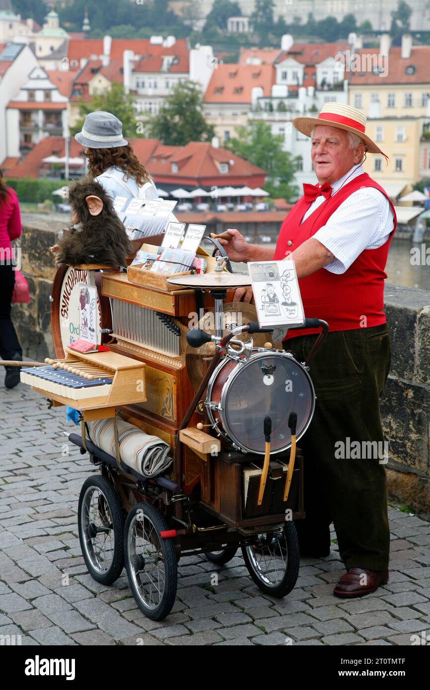 Mann, der eine traditionelle Musikbox auf der Karlsbrücke spielt, Prag, Tschechien. Stockfoto