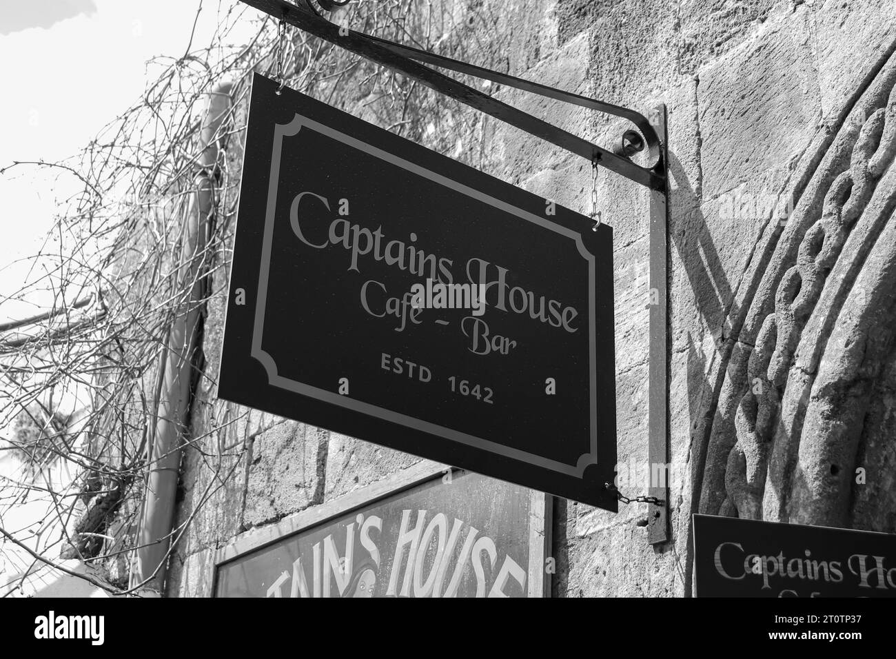 Captains House Cafe: Das Schild für den Eingang des Bar-Restaurants befindet sich in Lindos Town in Schwarz-weiß Stockfoto