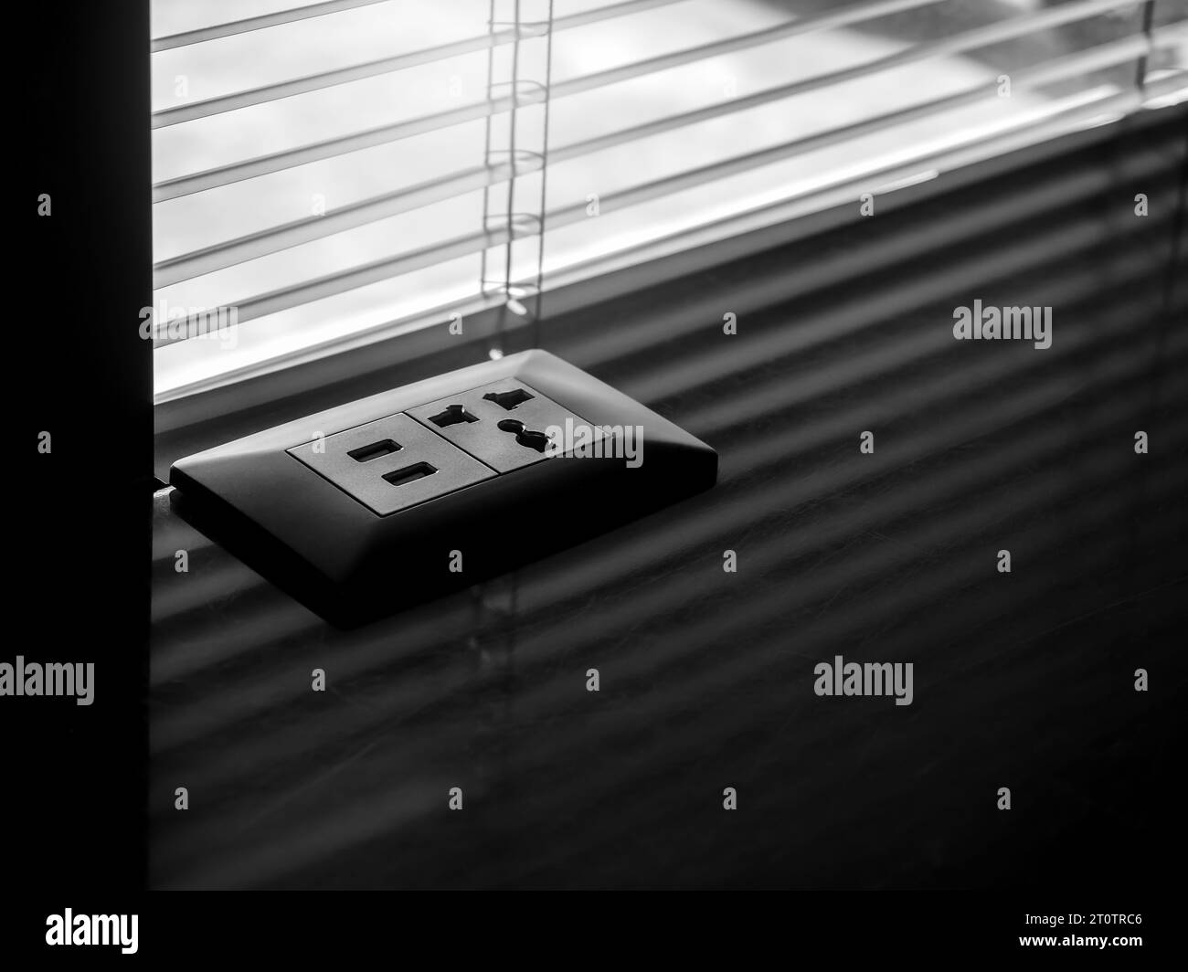 Schwarze Dual-USB-Stecker und -Buchsen für Schreibtischmontage auf dunklem Marmortisch in der Nähe des Fensters mit Lüftungsschlitz, mit Kopierraum. Business Technology-Konzept. Auslass p Stockfoto