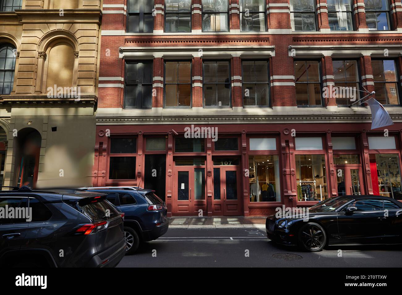 Stadtblock mit alten Gebäuden und Verkehr, der am Herbsttag in New york City auf der Straße unterwegs ist Stockfoto