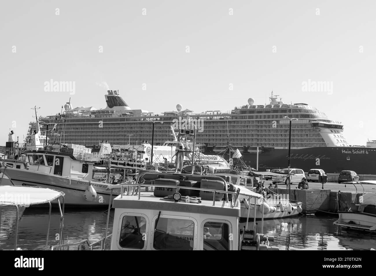 Mein Schiff 6, ein Kreuzfahrtschiff von TUI Cruises, legte in Schwarz-weiß am belebten Hafen von Rhodos in Griechenland an Stockfoto
