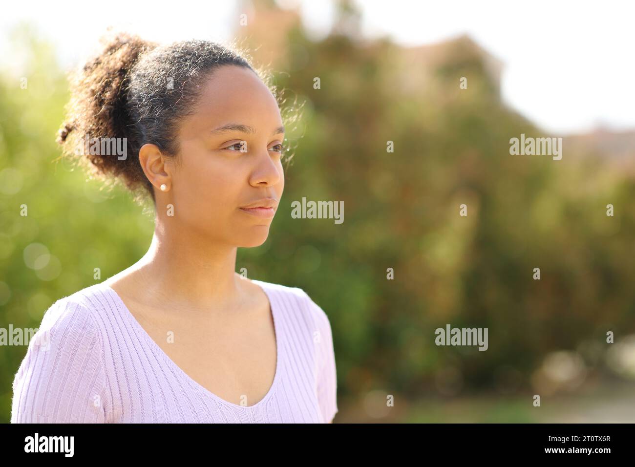 Porträt einer ernsten schwarzen Frau in einem Park, die wegschaut Stockfoto