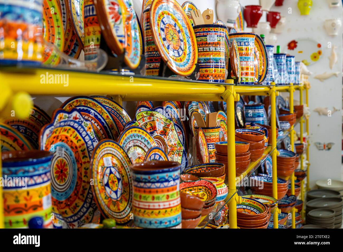 LAGOS, PORTUGAL - 27. FEBRUAR 2023: Auswahl an traditionellen Töpferbechern, -Schalen und anderen handgefertigten Tassen aus lackiertem Backton in Lagos, Portugal o Stockfoto