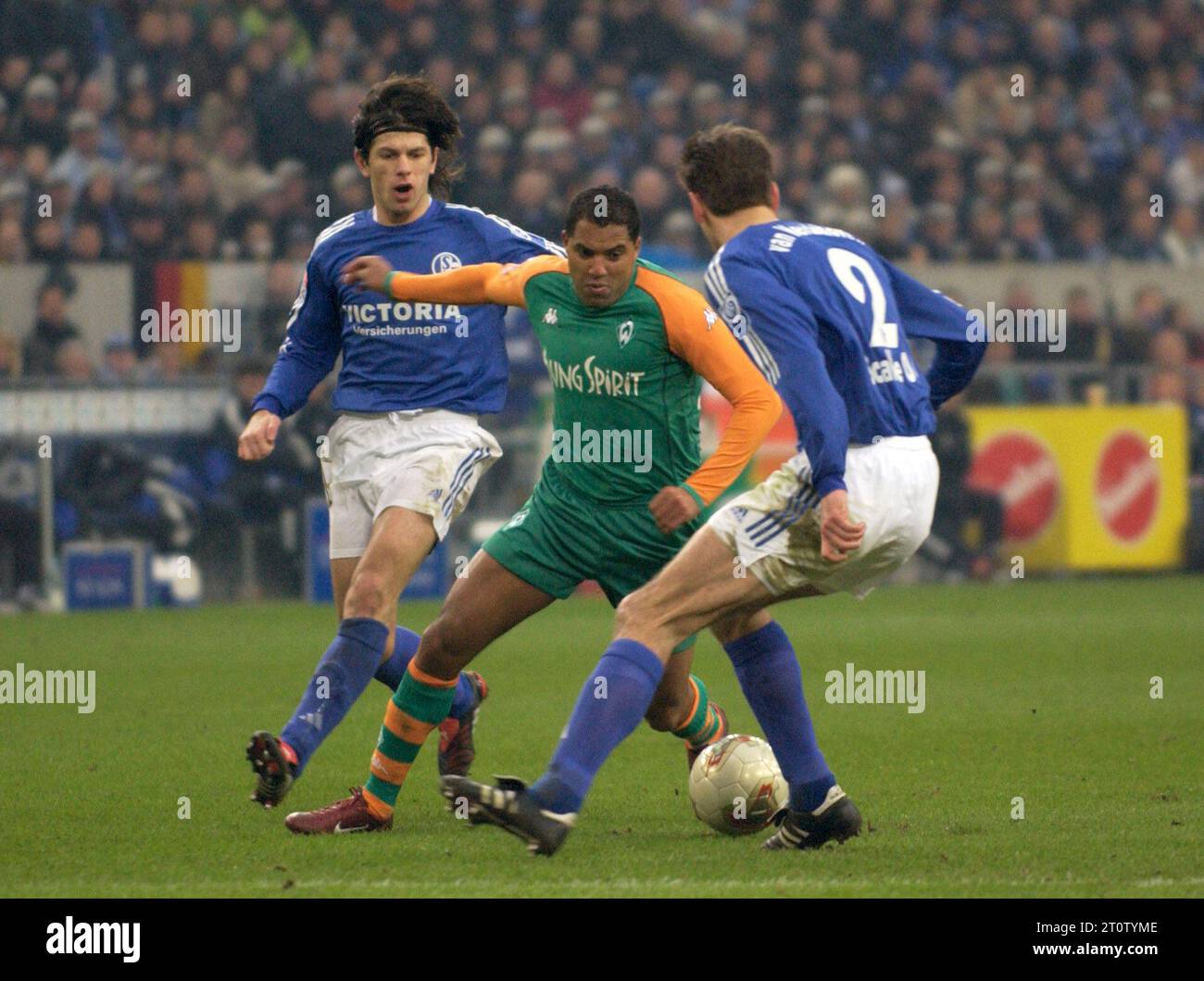 Gelsenkirchen Deutschland, 21.2.2004 Fußball: Bundesligasaison 2003/04, Schalke 04 (S04, blau) vs Werder Bremen (WBR, grün) 0:0 — von links: Kobiashvili (S04), Ailton (WBR), Van Kerkhoven (S04) Stockfoto