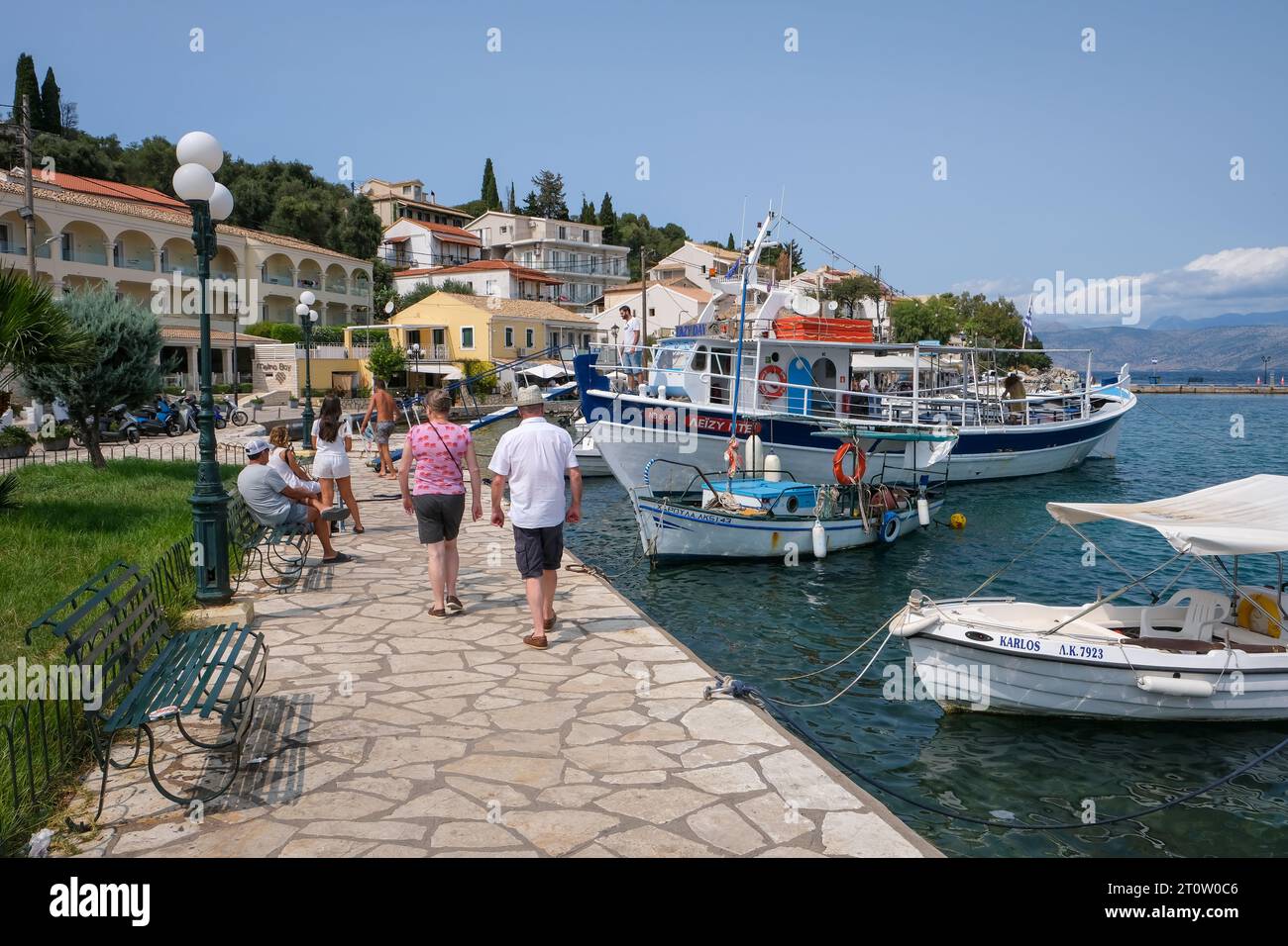 Kassiopi, Korfu, Griechenland - Fischerboote und ein Ausflugsboot im Hafen von Kassiopi, einer kleinen Hafenstadt im Nordosten der griechischen Insel Cor Stockfoto