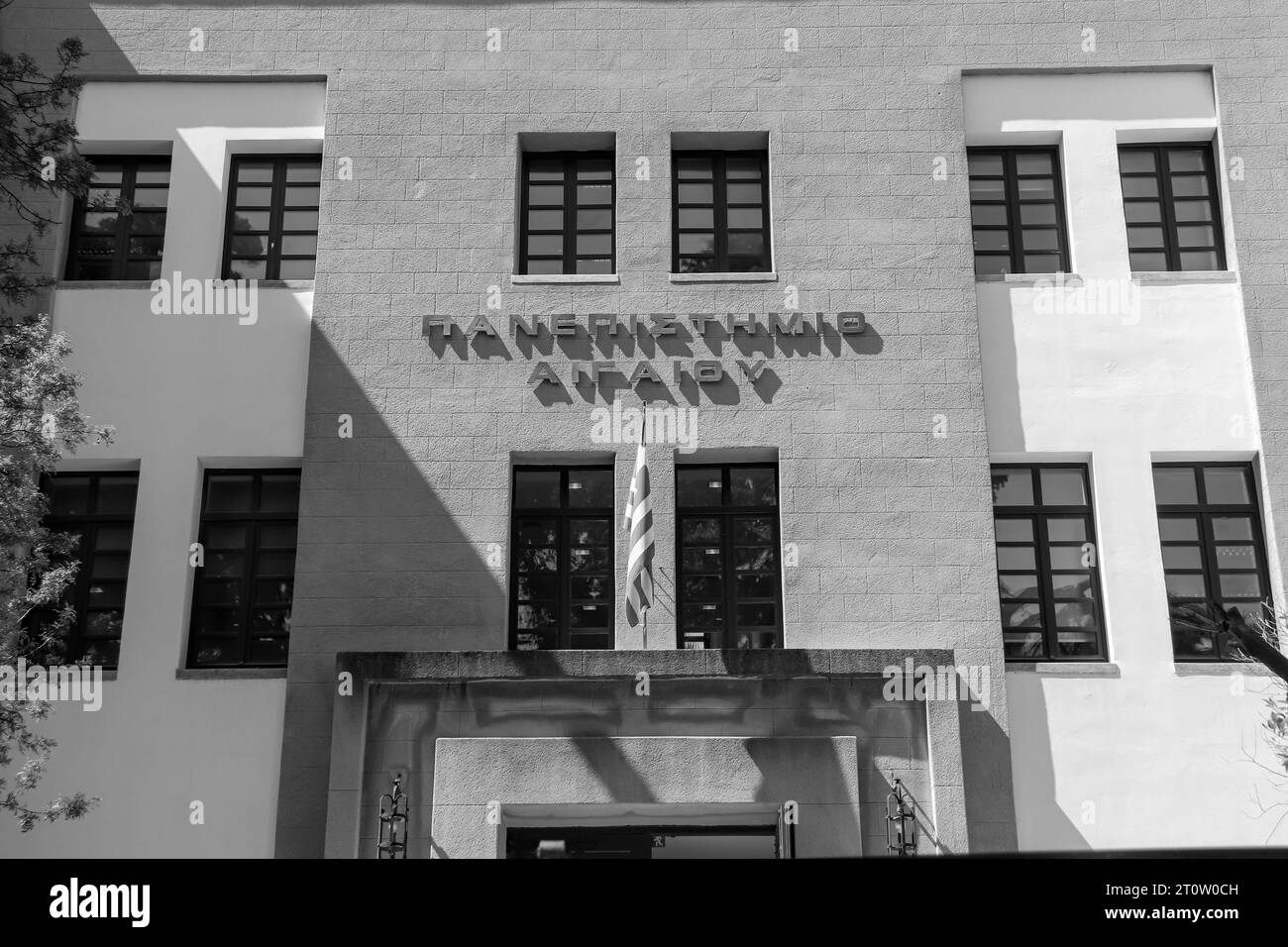 Universität der Ägäis für Hochschulbereich in Rhodos-Stadt, Griechenland, Vordereingang und Nationalflagge in schwarz-weiß Stockfoto