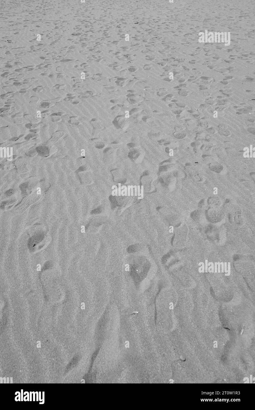 Abstrakter Schwarzweiß-Sandstrand mit Fußabdruck Stockfoto