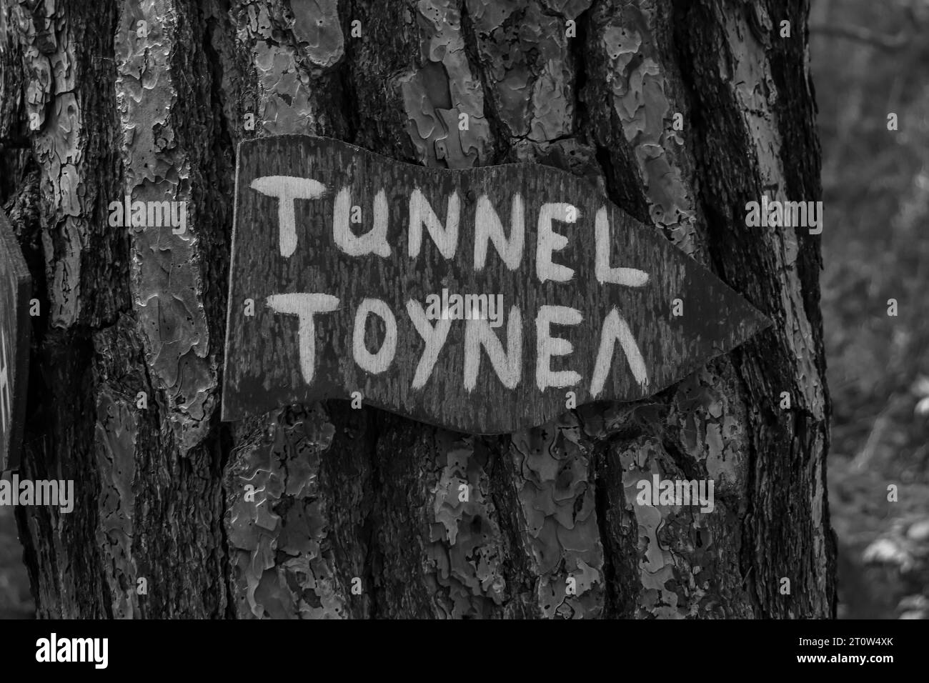 Pfeil-Richtungsschild zum Tunnel in Seven Springs (Epta Piges) berühmte Touristenattraktion in Schwarz-weiß Stockfoto