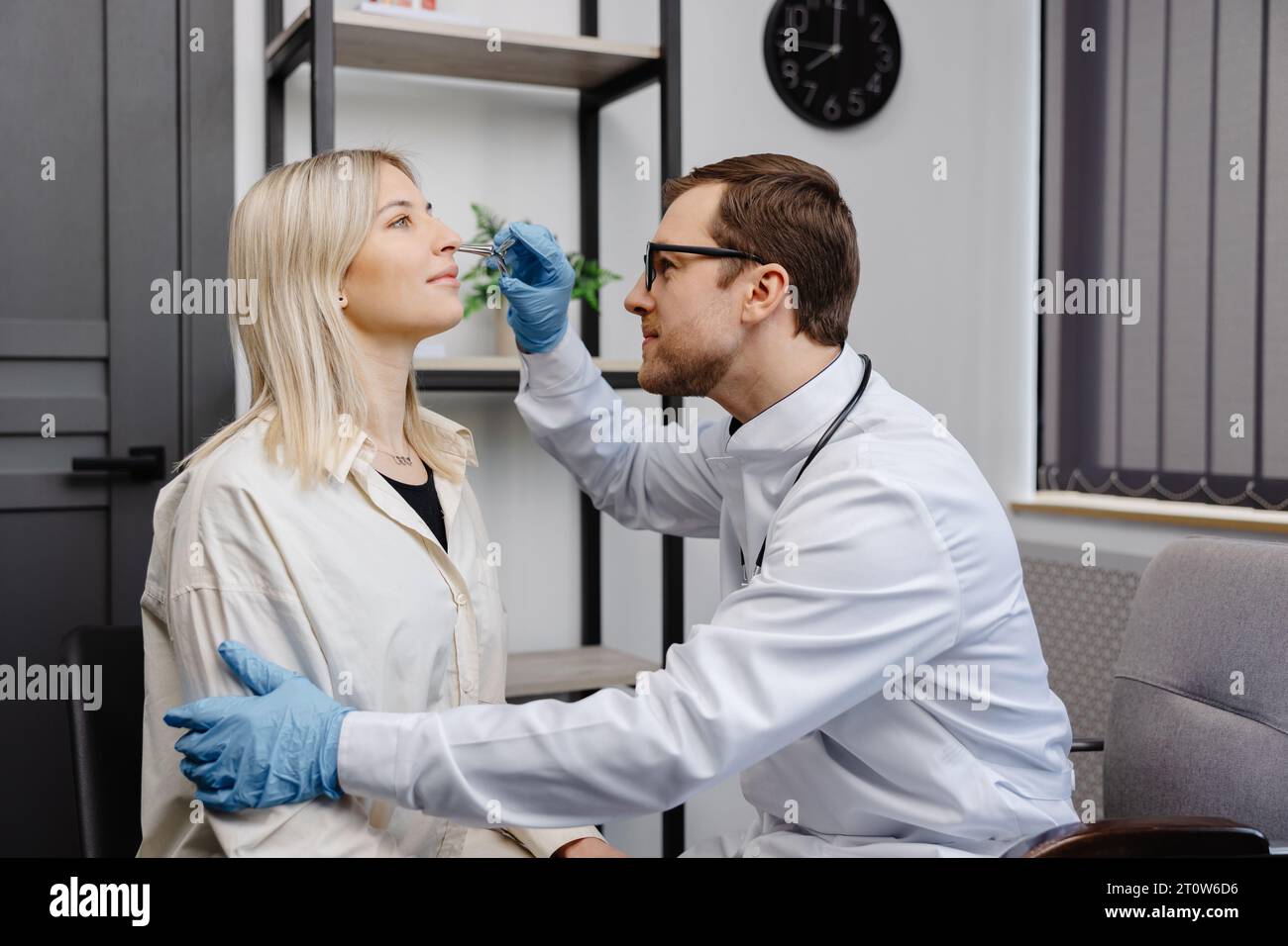 Ein junger attraktiver HNO-Arzt untersucht die Nase eines jungen Patienten während einer ärztlichen Untersuchung in der HNO-Sprechstunde. Stockfoto