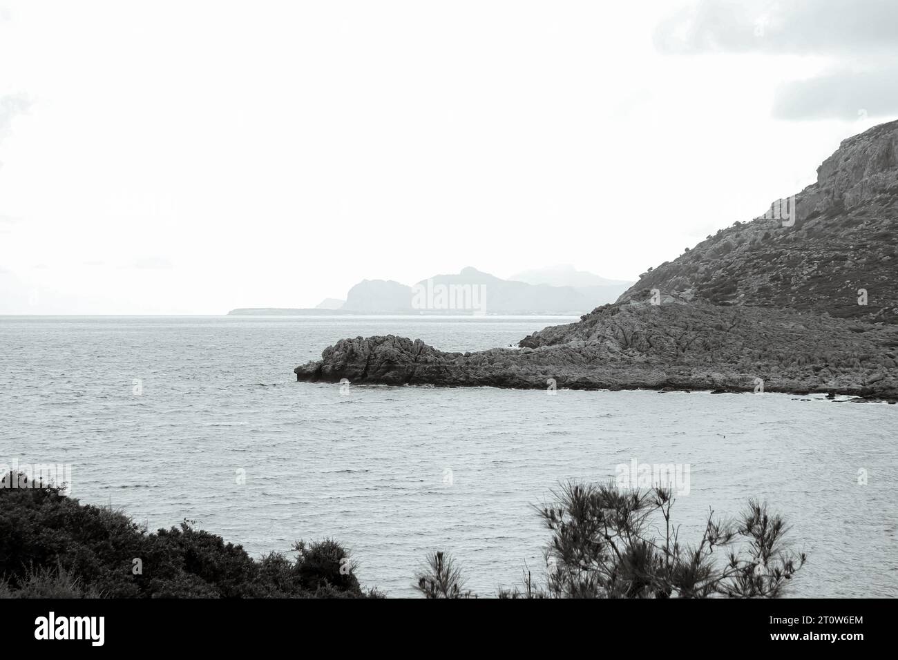 Schwarz-weiß Anthony Quinn Bay Strand Felsformation Hügel im Ozean Wasser Stockfoto