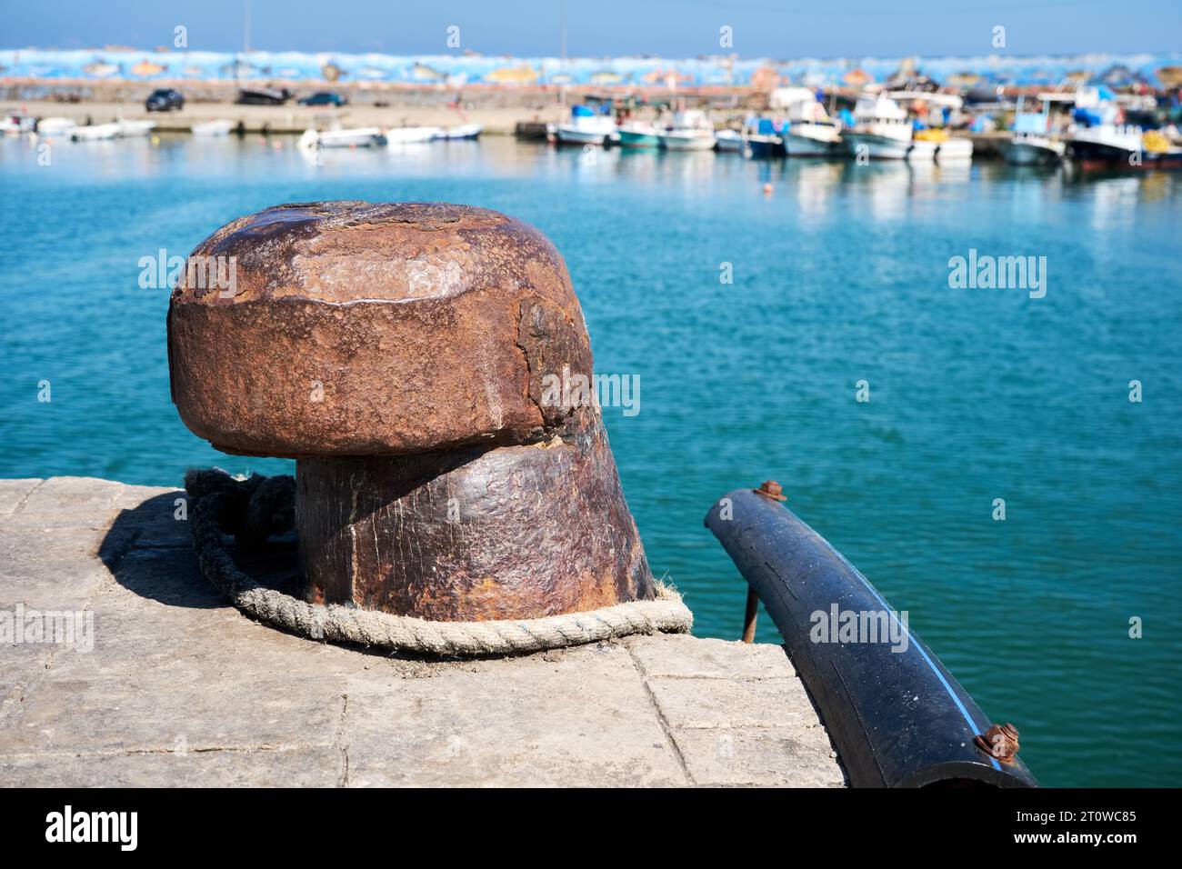 Rostiger alter Stahlanker mit Meer- und Fischerboothintergrund. Stockfoto