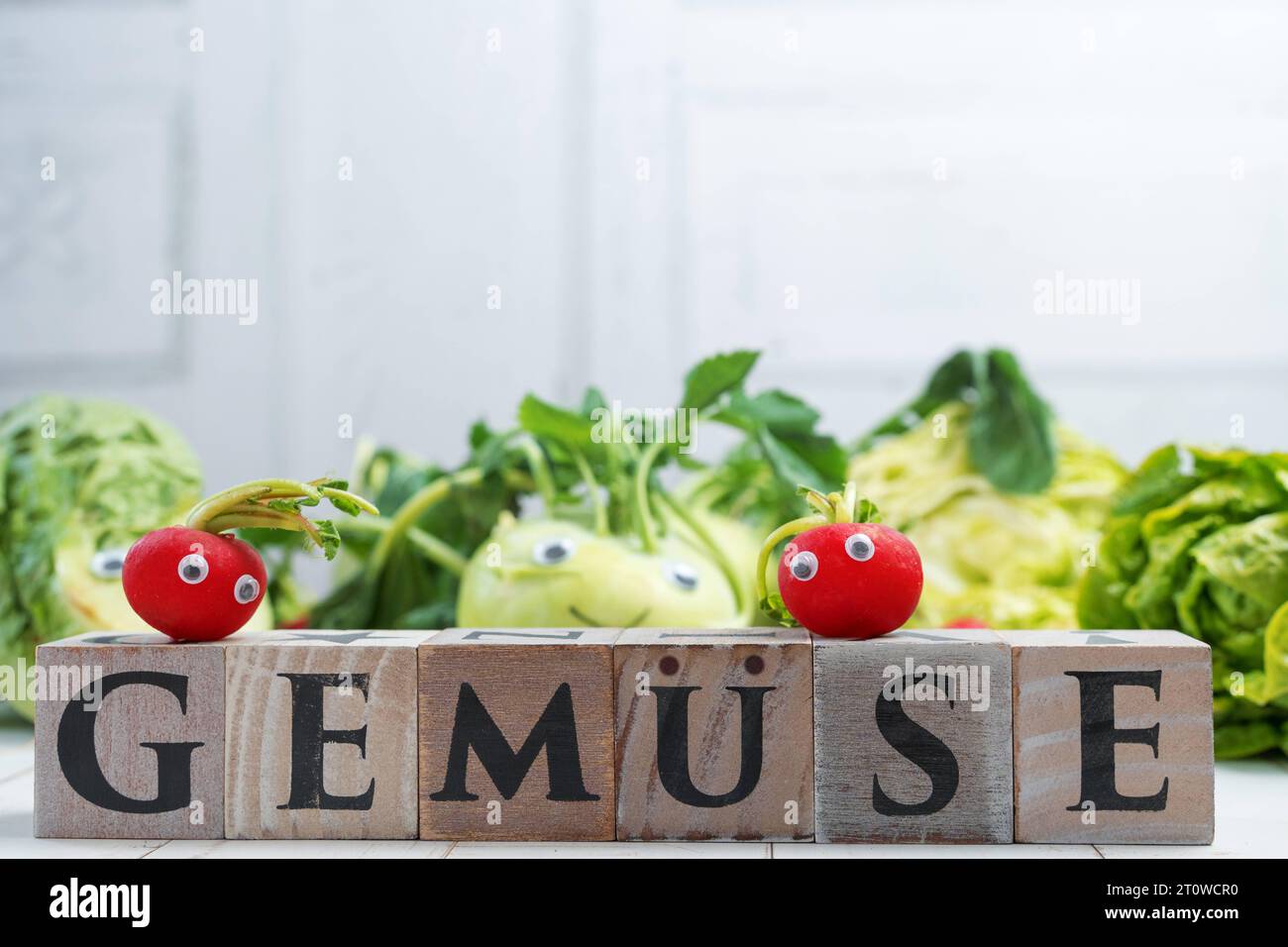 8. Februar 2023: Fröhliches Gemüse, Radieschen und Kohlrabi mit Augen und lächelndem Gesicht im Holzwürfel im Vordergrund mit Inschrift: Gemüse. Healthy Food Concept *** Glückliches Gemüse, radischen und Kohlrabi mit Augen und lächelndem Gesicht im Vordergrund Holzwürfel mit Aufschrift: Gemüse. Gesunde Ernährung Konzept Credit: Imago/Alamy Live News Stockfoto