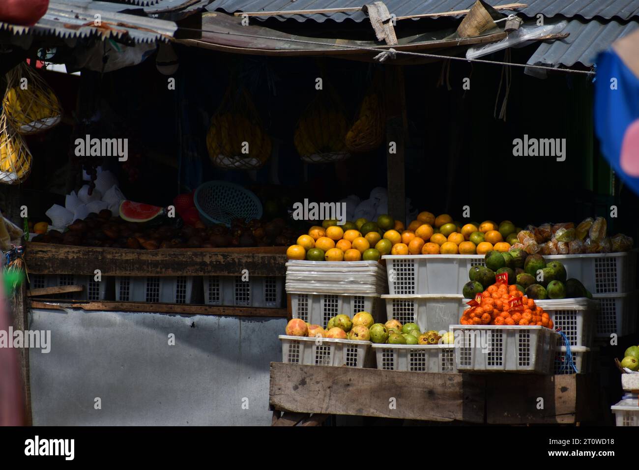 Orangen und andere Früchte werden vor einem halbständigen Stand auf einem traditionellen Markt in Java ausgestellt. Stockfoto