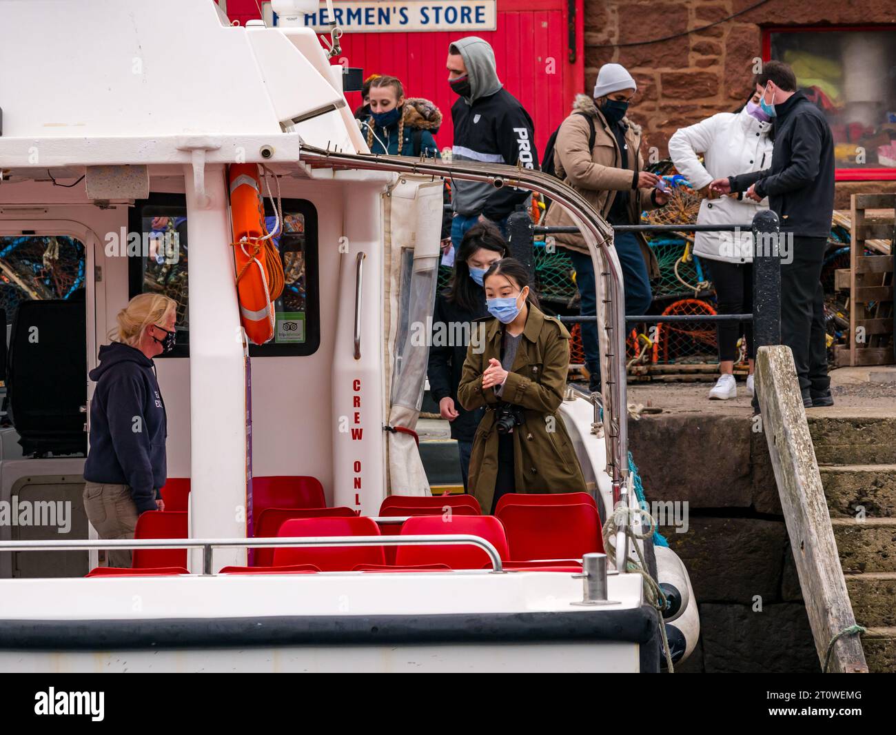 Passagiere mit Gesichtsmasken an Bord des Seafari-Touristenbootes im Hafen von North Berwick. East Lothian, Schottland, Großbritannien Stockfoto