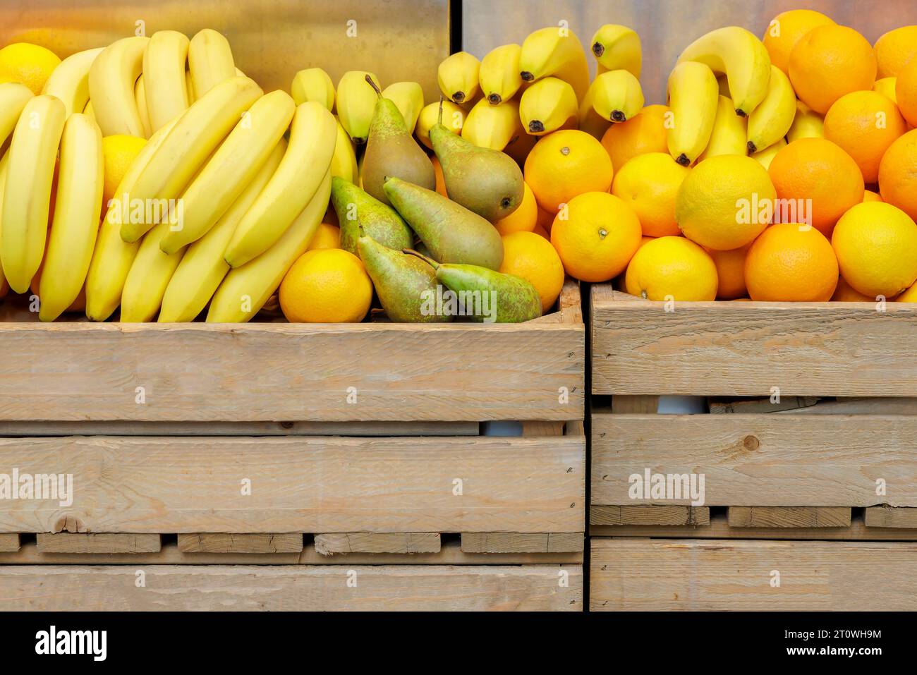 Marktstand mit frischen Bananen, Birnen und Orangen in Holzkisten Stockfoto