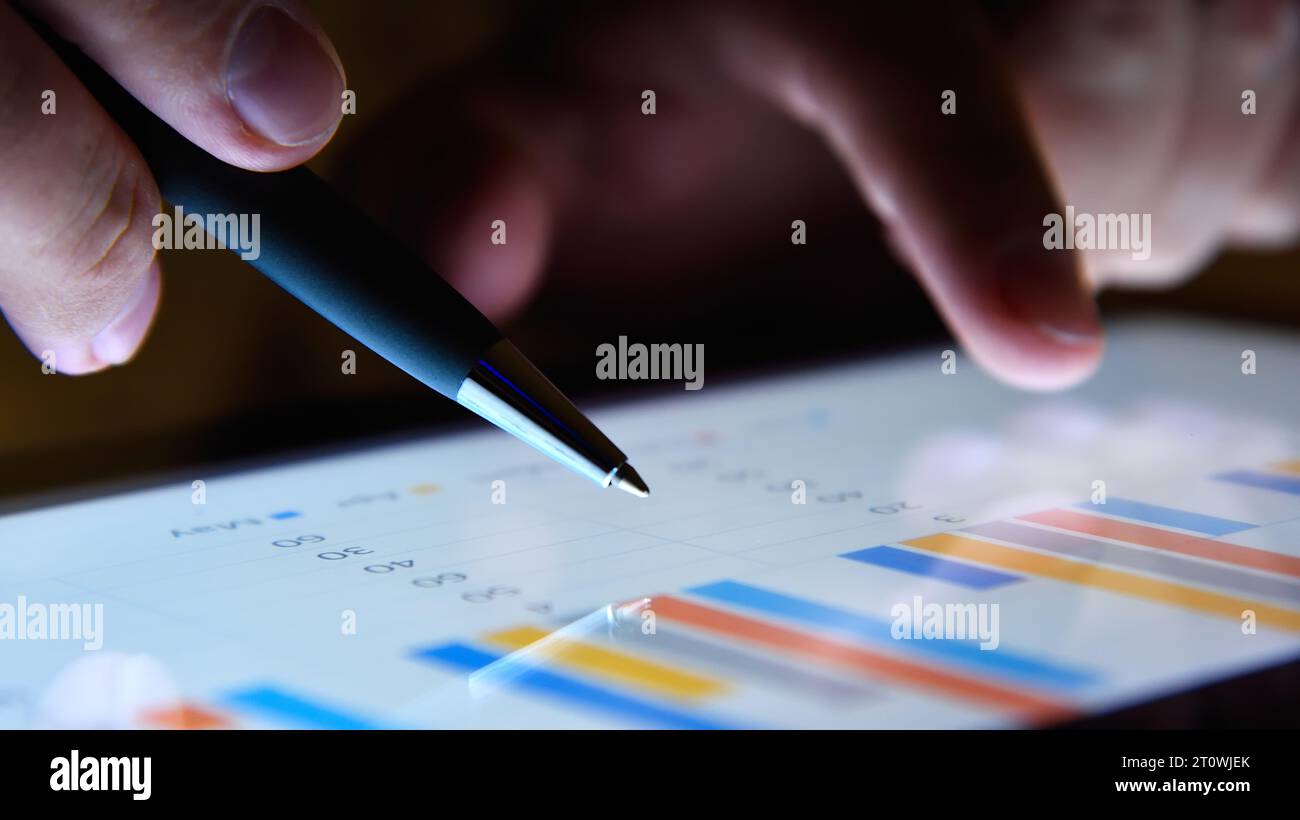 Nahaufnahme der Hand eines Geschäftsmannes mit Finanzdiagrammen und Diagrammen in einem digitalen Tablet. Geschäfts- und Erfolgskonzept. Stockfoto