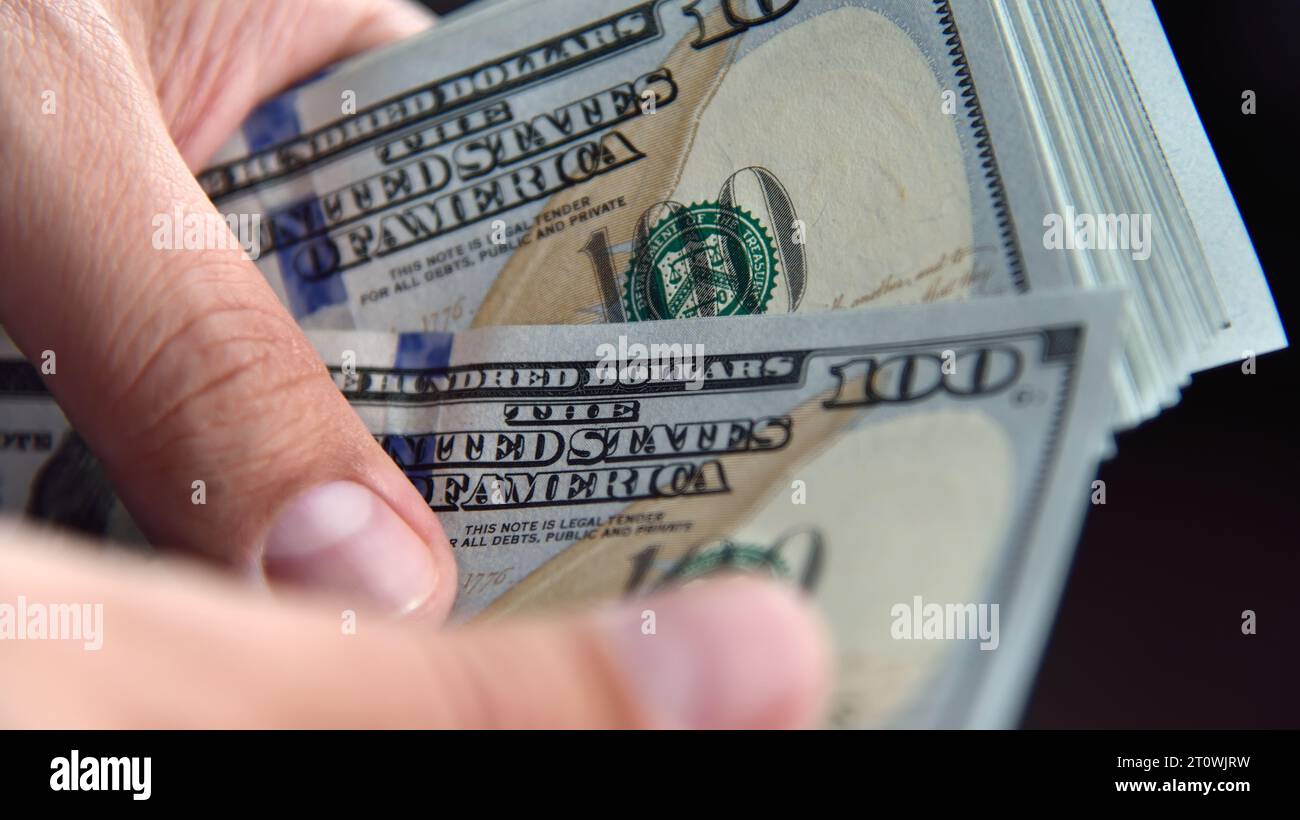 Nahaufnahme eines Geschäftsmannes zählt us-Dollar in Händen. Finanzieller Erfolg und Vermögenskonzept. Stockfoto
