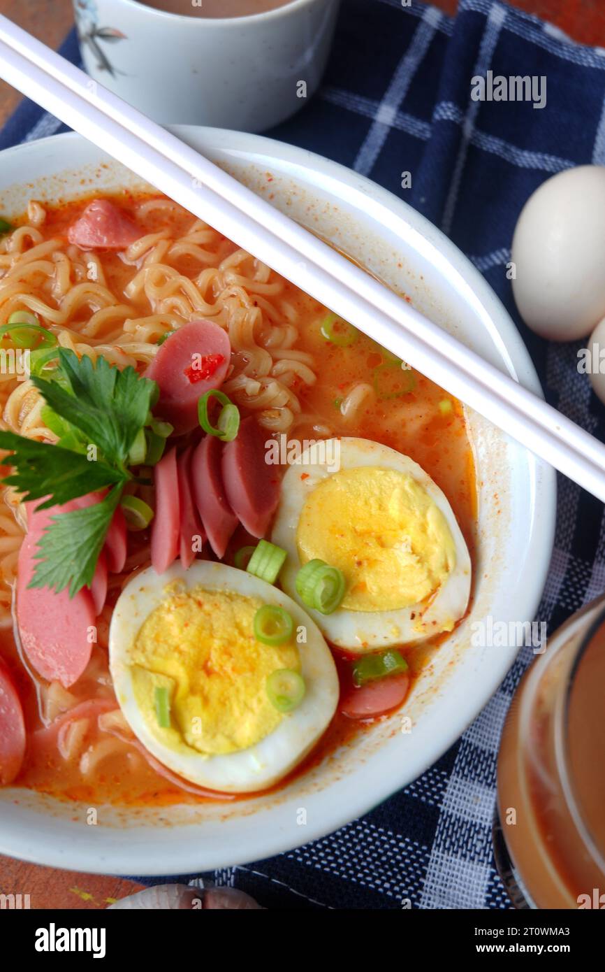 Foto von Nudelsuppe mit Belägen wie Würstchen, Eiern und Gemüse Stockfoto
