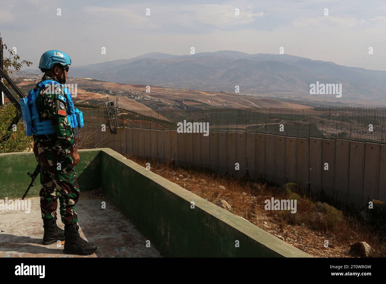9. Oktober 2023, Libanon, Adaisseh: Indonesische Soldaten der UN-Friedenstruppe im Südlibanon (UNIFIL) sichern ein Gebiet im südlibanesischen Dorf Adaisseh an der libanesisch-israelischen Grenze, wo israelische Siedlungen im Hintergrund zu sehen sind. Die Interimstruppen der Vereinten Nationen im Südlibanon (UNIFIL) haben nach der massiven Eskalation der Gewalt zwischen den Palästinensern und dem jüdischen Staat auf größtmögliche Zurückhaltung an der libanesischen Grenze zu Israel gedrängt. Foto: Marwan Naamani/dpa Stockfoto