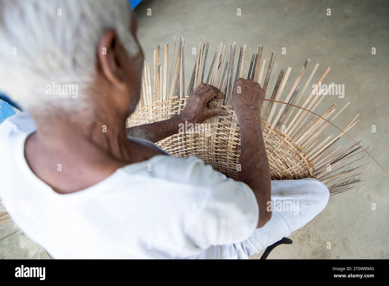 Ein älterer Mann, der umweltfreundliche Bambusstreifen-Korb webt, Majuli, Assam, Nordostindien, Asien Stockfoto