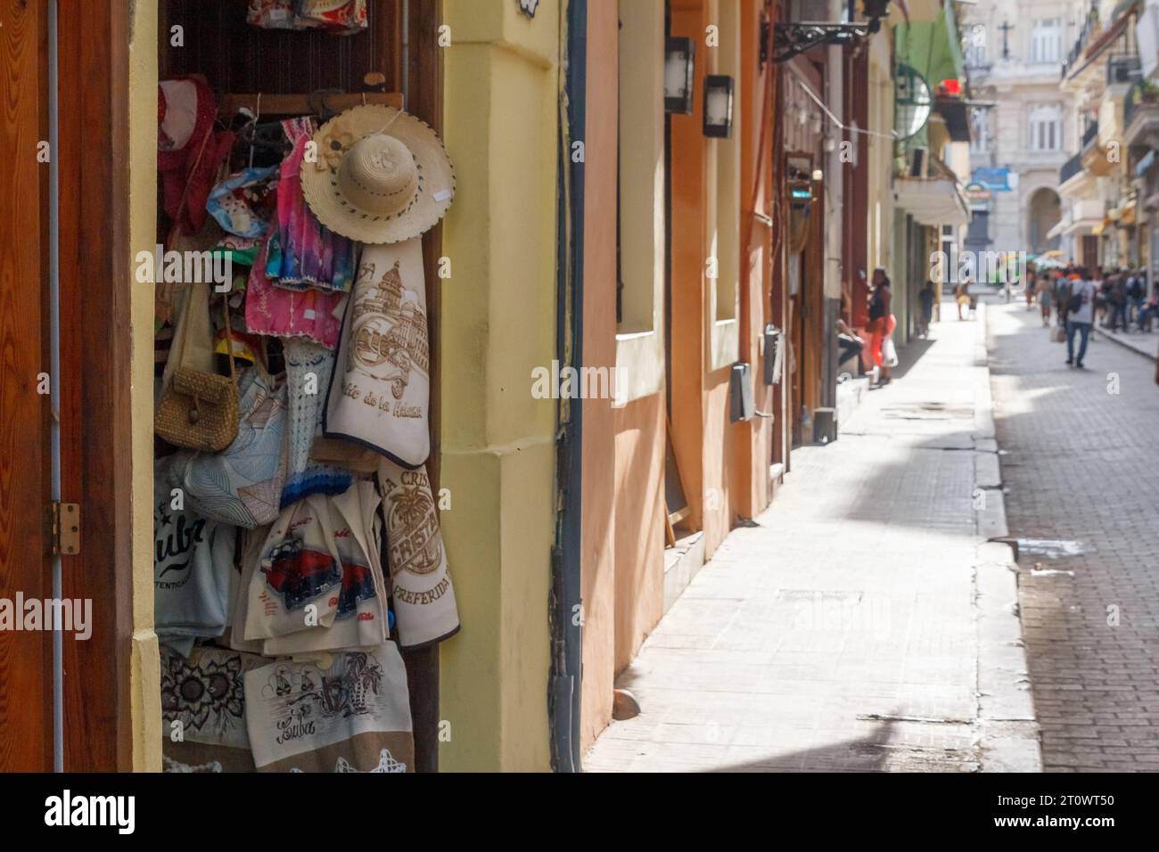 Verschiedene Waren werden in einer Tür eines Hauses in Old Havanna abgespielt. Das kleine Einzelhandelsunternehmen hat keine Kunden, der Bürgersteig ist leer. Stockfoto