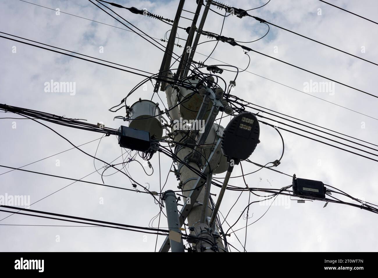 Ein Telefonmast mit komplizierten elektrischen Drähten Stockfoto