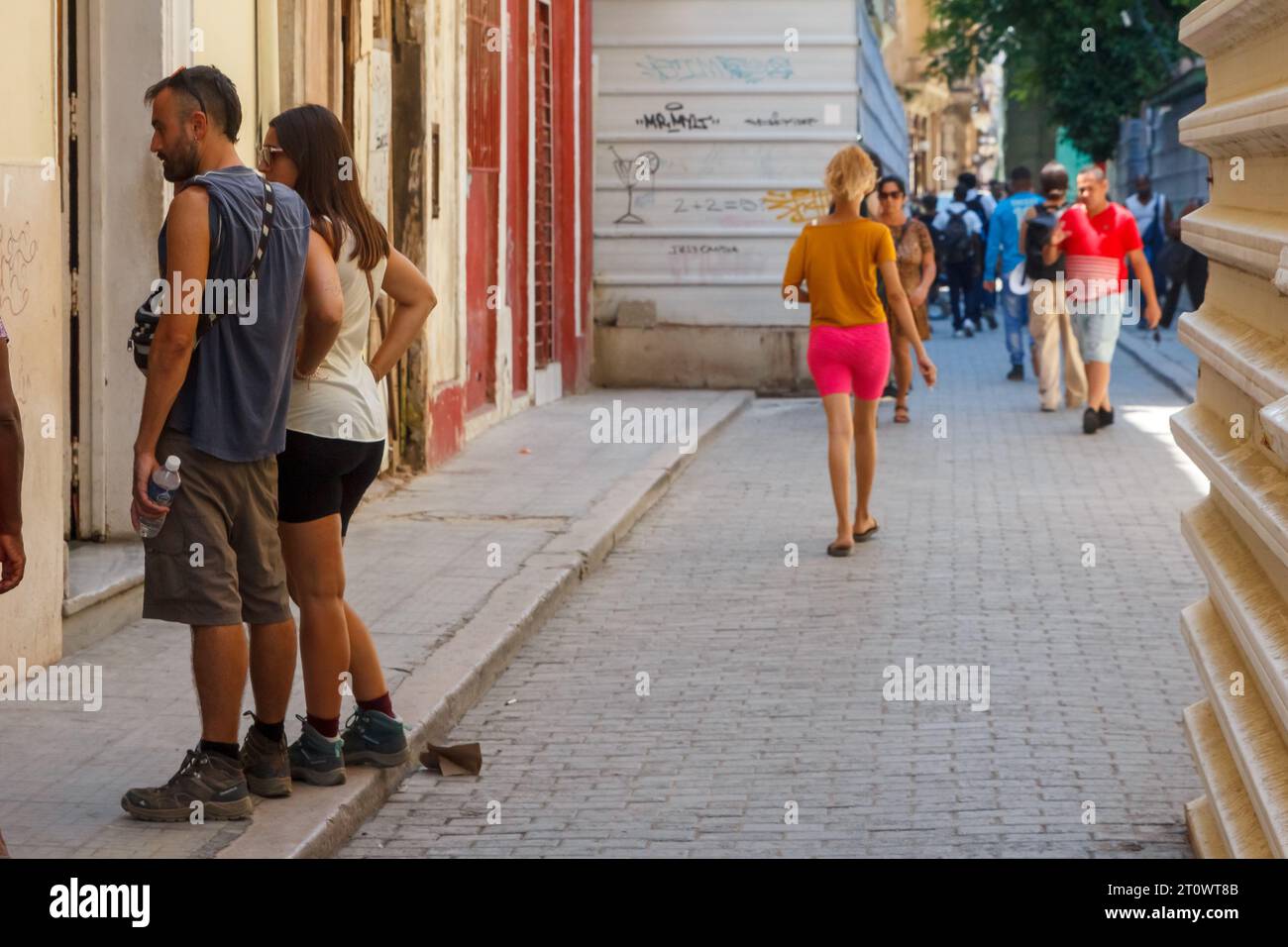 Lebensstil echter Menschen in Old Havanna. Die Stadtstraße hat einen Kopfsteinpflasterboden. Zwei Metallzäune schützen Baustellen, die repariert oder umgebaut werden. Stockfoto