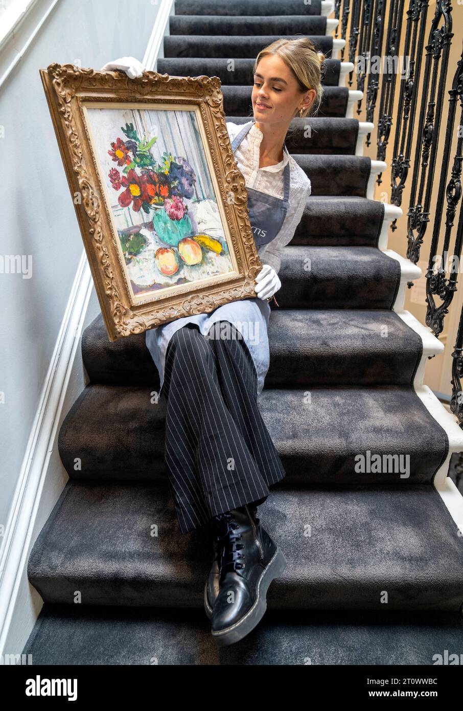 Bonham’s Gemma Radburn-Todd mit einem Ölgemälde von George Leslie Hunter mit dem Titel „Stillleben mit Dahlias“ (1925), bevor es für einen Besuch in Bonhams Edinburgh vor dem Verkauf der Scottish Art am Mittwoch gehängt wird. Bilddatum: Montag, 9. Oktober 2023. Stockfoto