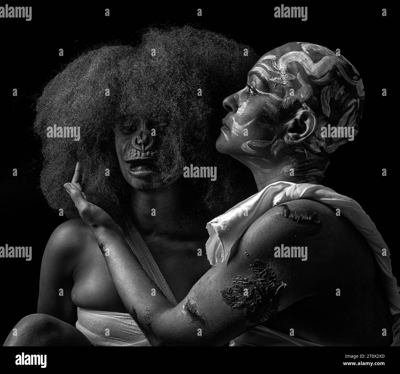 Ein unauffälliges Atelierbild von Mutter und Tochter in Narben und Affengesicht, das den Missbrauch schwarzer Frauen über die Jahre in Schwarzweiß darstellt Stockfoto
