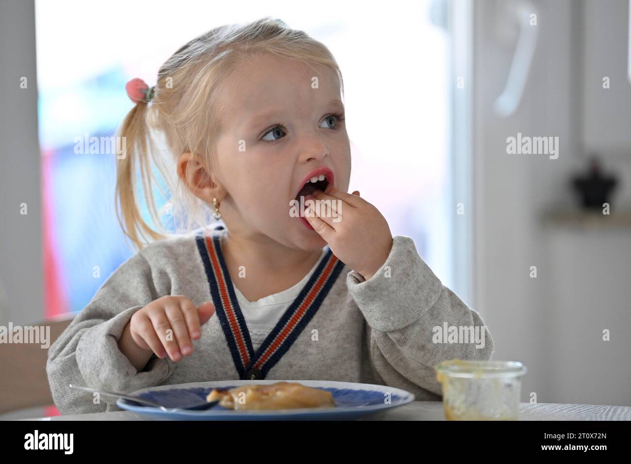 Kleines Mädchen, 2 Jahre, blond, isst Pfannkuchen, Pfannkuchen, Teller, Löffel, Essen, Stuttgart, Baden-Württemberg, Deutschland Stockfoto
