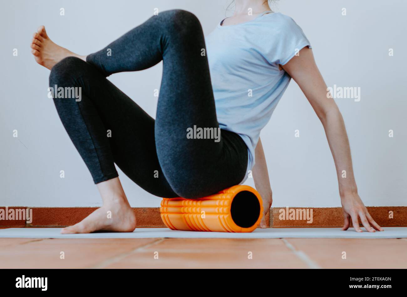 Frau, die Glute-Myofascial-Freisetzung auf Schaumwalze macht Stockfoto