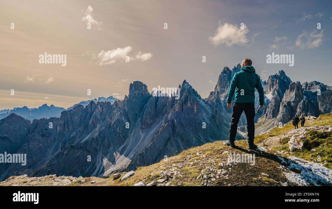 Inmitten der Pracht der Berge steht ein einsamer Mann als Zeugnis menschlichen Geistes und Abenteuers. Stockfoto