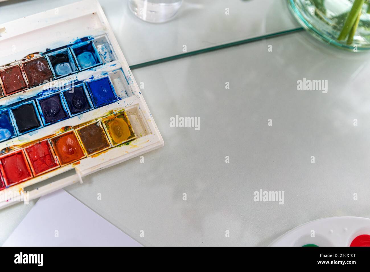 Dieses Nahaufnahme-Foto zeigt eine Aquarellpalette. Die Palette ist so angeordnet, dass sie aussieht, als würde sie in einem Gemälde verwendet. Stockfoto