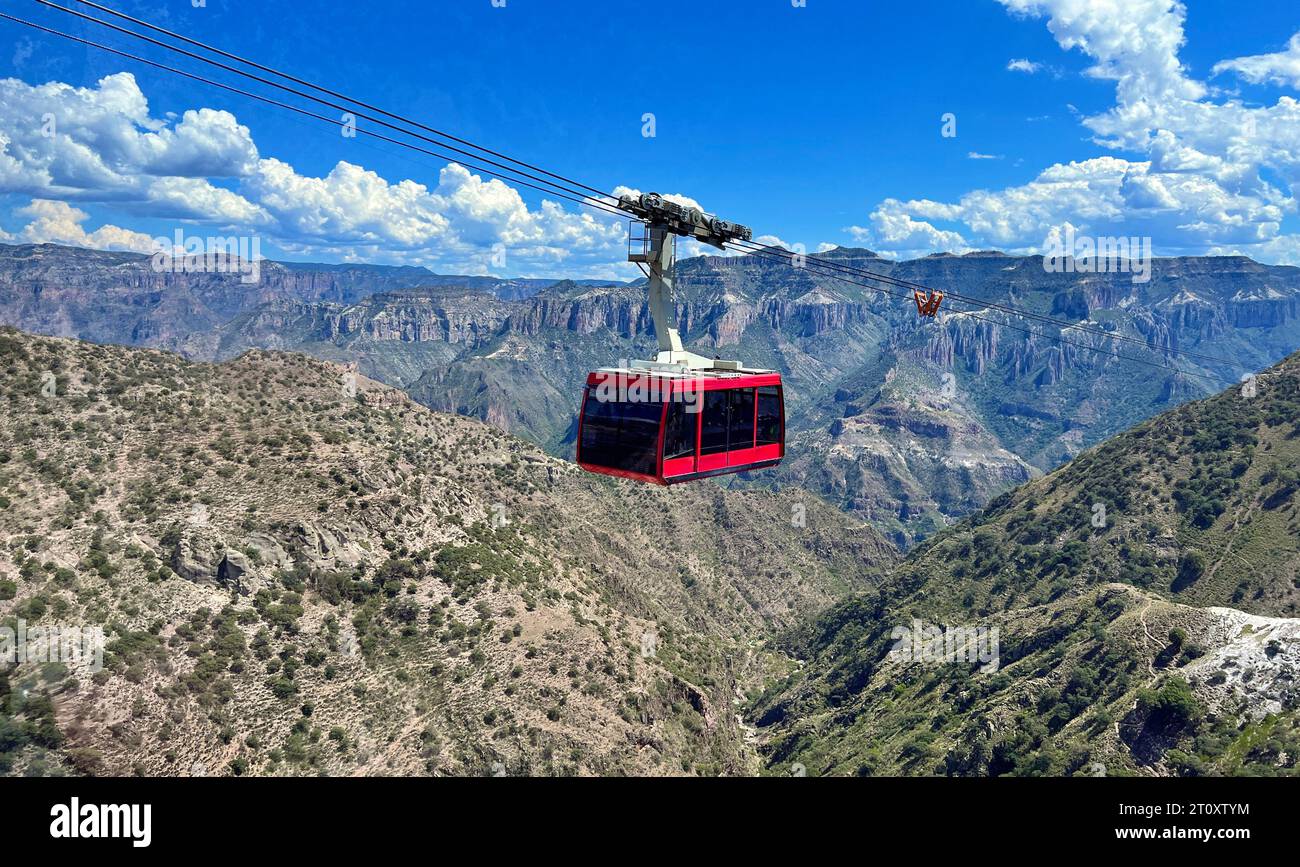 Ein sonnendurchfluteter Panoramablick auf den Copper Canyon, mit einer Seilbahn voller Touristen, die Momente vor der weitläufigen naturkulisse unter einer fast klaren Oberfläche festhalten Stockfoto