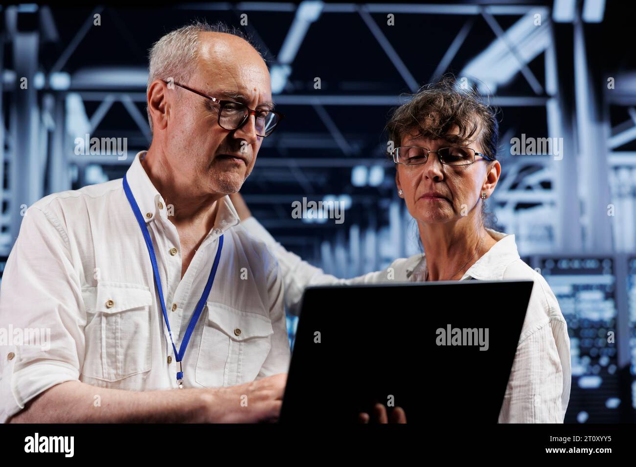 Alte Führungskräfte von Datenspeicherunternehmen, die Diagnosebewertungen auf High-Tech-Arbeitsbereichsservern durchführen. Ingenieure, die bei der jährlichen Wartung auf potenzielle Systemmängel achten Stockfoto Alte Führungskräfte von Datenspeicherunternehmen, die Diagnosebewertungen auf High-Tech-Arbeitsbereichsservern durchführen. Ingenieure, die bei der jährlichen Wartung auf potenzielle Systemmängel achten Stockfoto