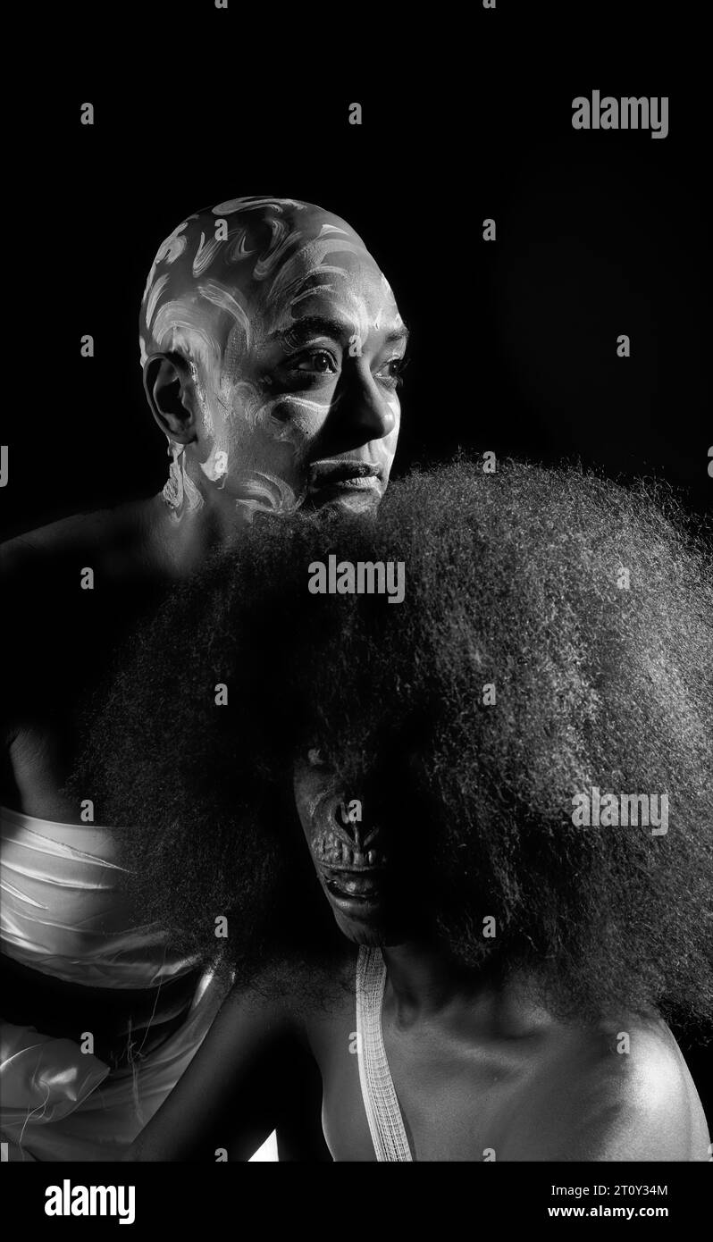 Ein unauffälliges Atelierbild von Mutter und Tochter in Narben und Affengesicht, das den Missbrauch schwarzer Frauen über die Jahre in Schwarzweiß darstellt Stockfoto