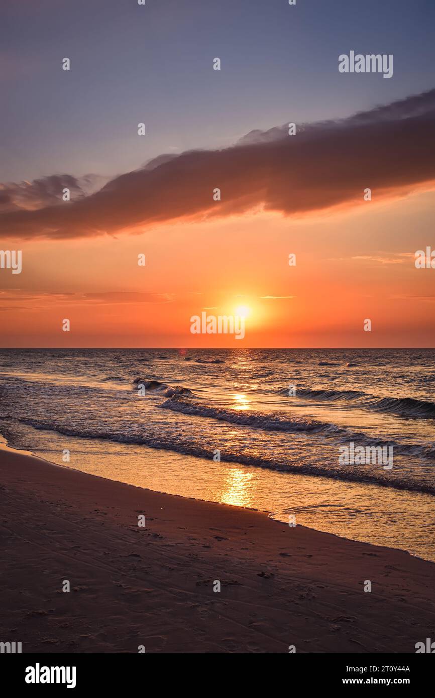 Wunderschöner, farbenfroher Sonnenuntergang über dem Meer. Sandstrand am Abend an der Polnischen Ostsee. Stockfoto