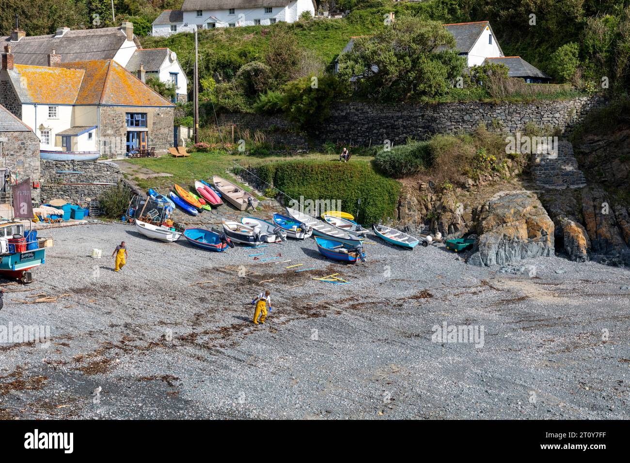 Cadgwith Cove Fischerdorf in Cornwall, zwei Fischer arbeiten am Strandhafen unten, England, Großbritannien, 2023 Stockfoto