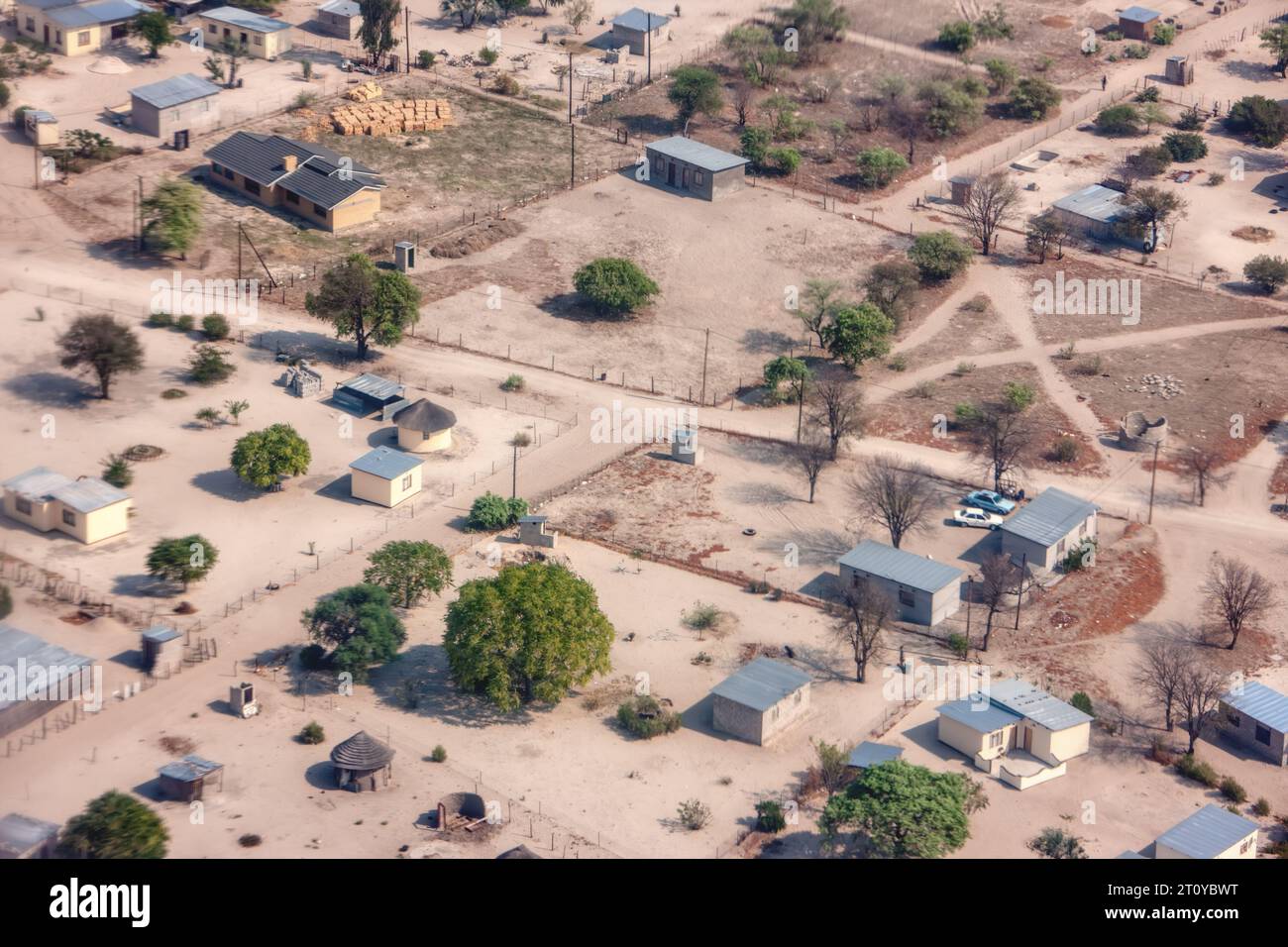 Luftaufnahme des typischen modernen afrikanischen Dorfes in botswana, mit staubigen unbefestigten Straßen und kubischen Gebäuden Stockfoto