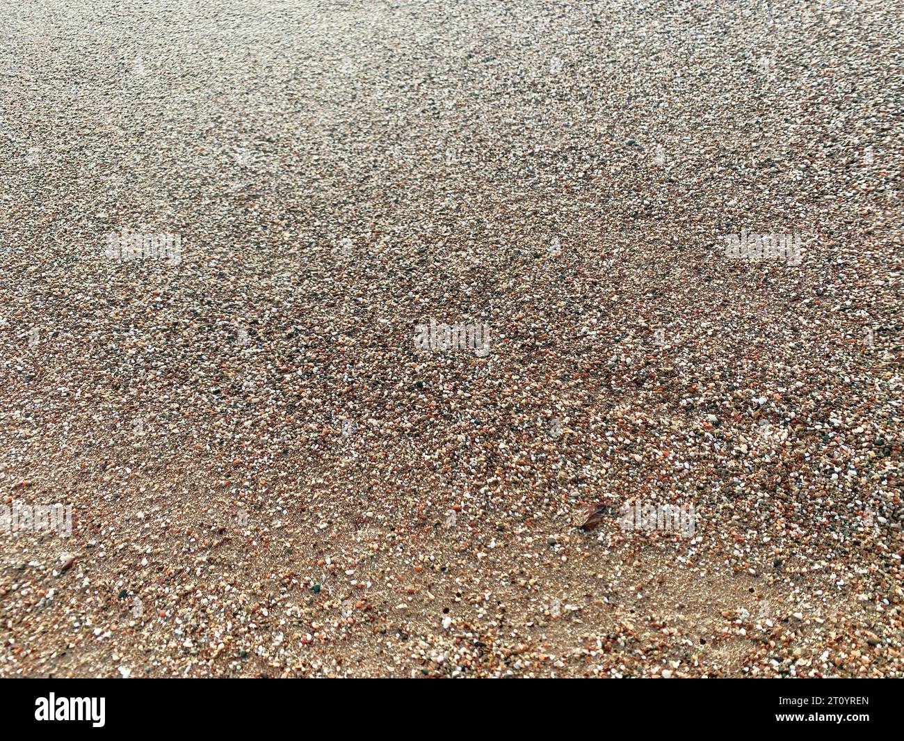 Abstrakte Textur von gelbem nassem Sand am Strand. Naturhintergründe und Muster Stockfoto