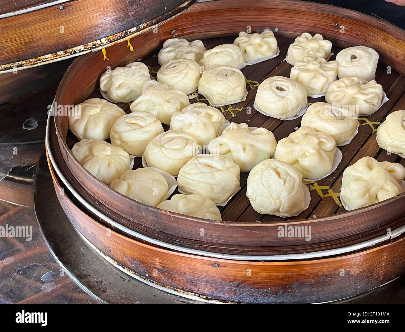 Bakpao, Baozi gedämpftes Brötchen, Pao, Dim Sum in einem Bambusdampfer. Eine Art Hefe-gesäuertes Brötchen in verschiedenen chinesischen Küchen. Stockfoto