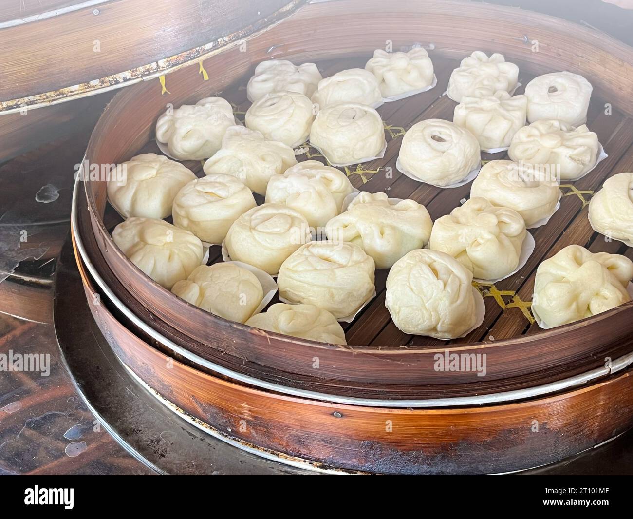 Bakpao, Baozi gedämpftes Brötchen, Pao, Dim Sum in einem Bambusdampfer. Eine Art Hefe-gesäuertes Brötchen in verschiedenen chinesischen Küchen. Stockfoto