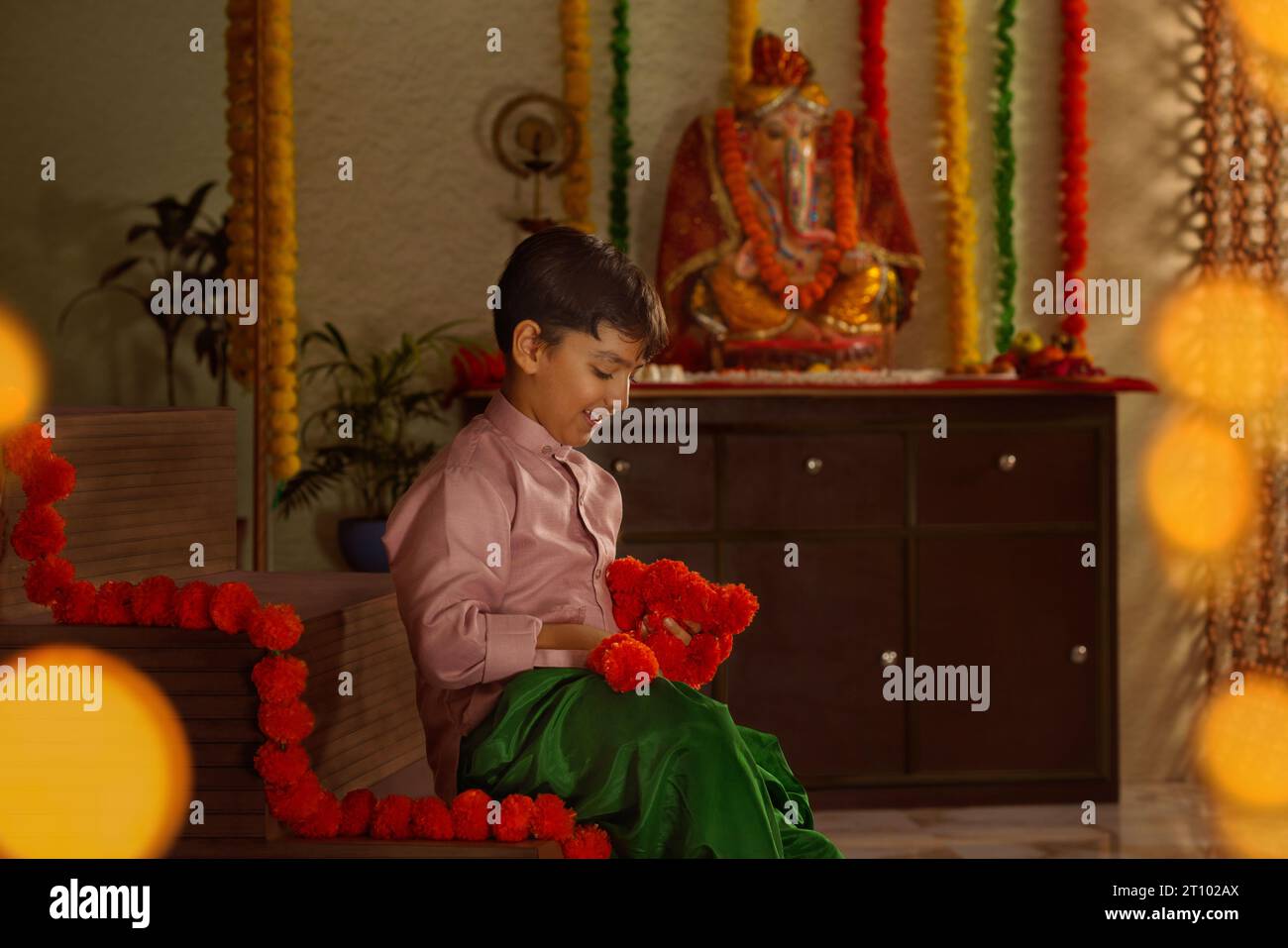 Junge mit Ringelblumengirlande anlässlich von Ganesh Chaturthi einem Festival das in Maharashtra ( Westindien ) gefeiert wird Stockfoto