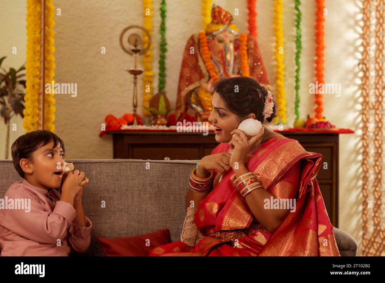Mutter und Sohn spielen miteinander während des Ganesh Chaturthi, einem Festival, das in Maharashtra (Westindien) gefeiert wird Stockfoto