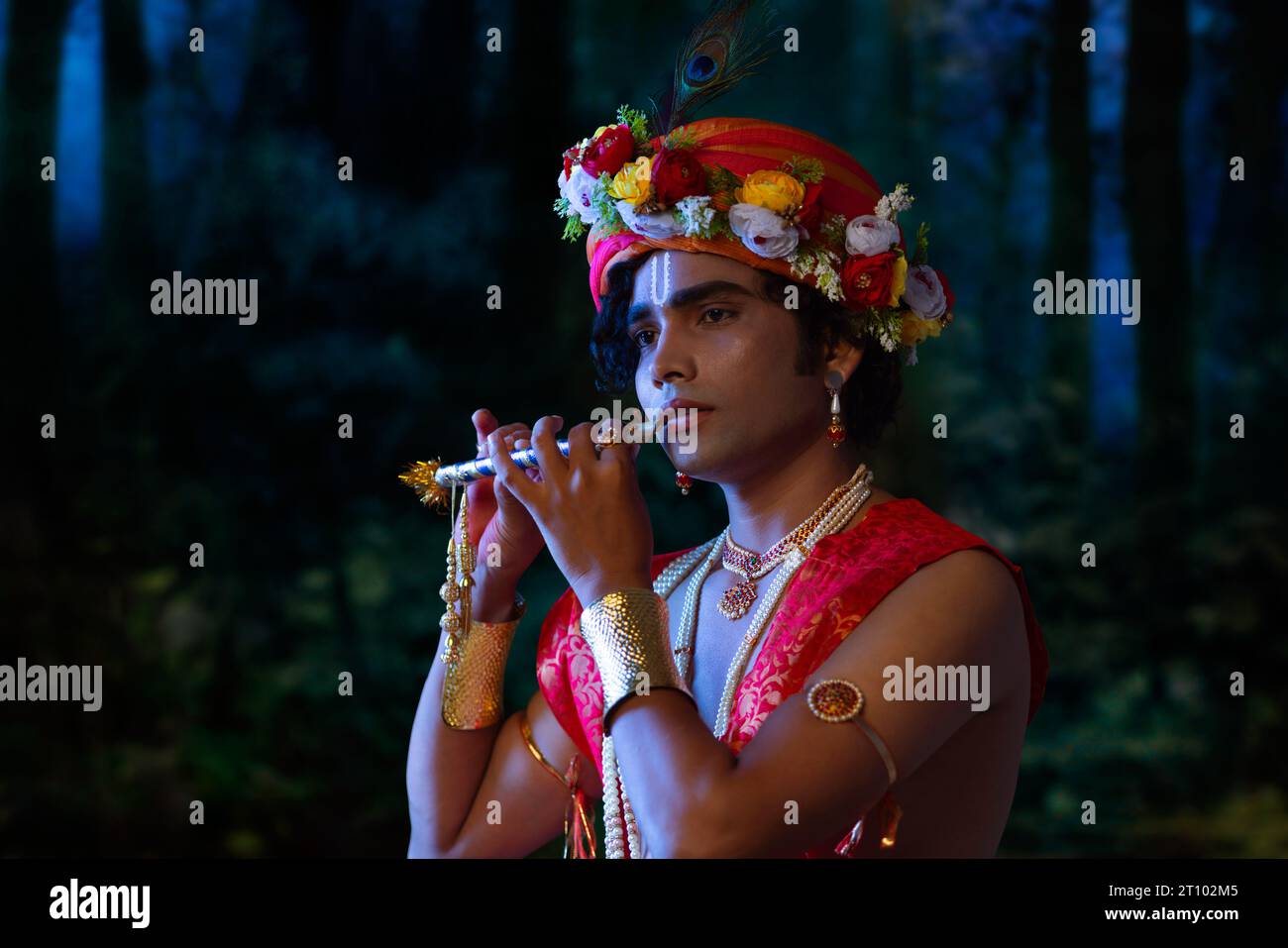 Porträt eines jungen Mannes, verkleidet als Lord Krishna und Flöte zu Janmashtami spielt Stockfoto