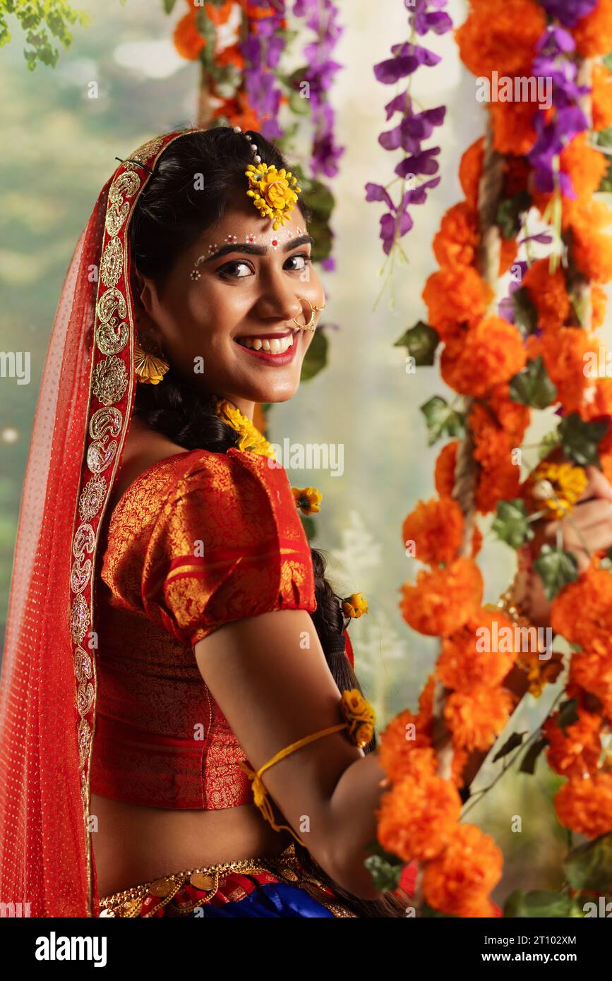 Eine junge Frau, verkleidet als Radha und sitzend auf einer Schaukel anlässlich von Janmashtami Stockfoto