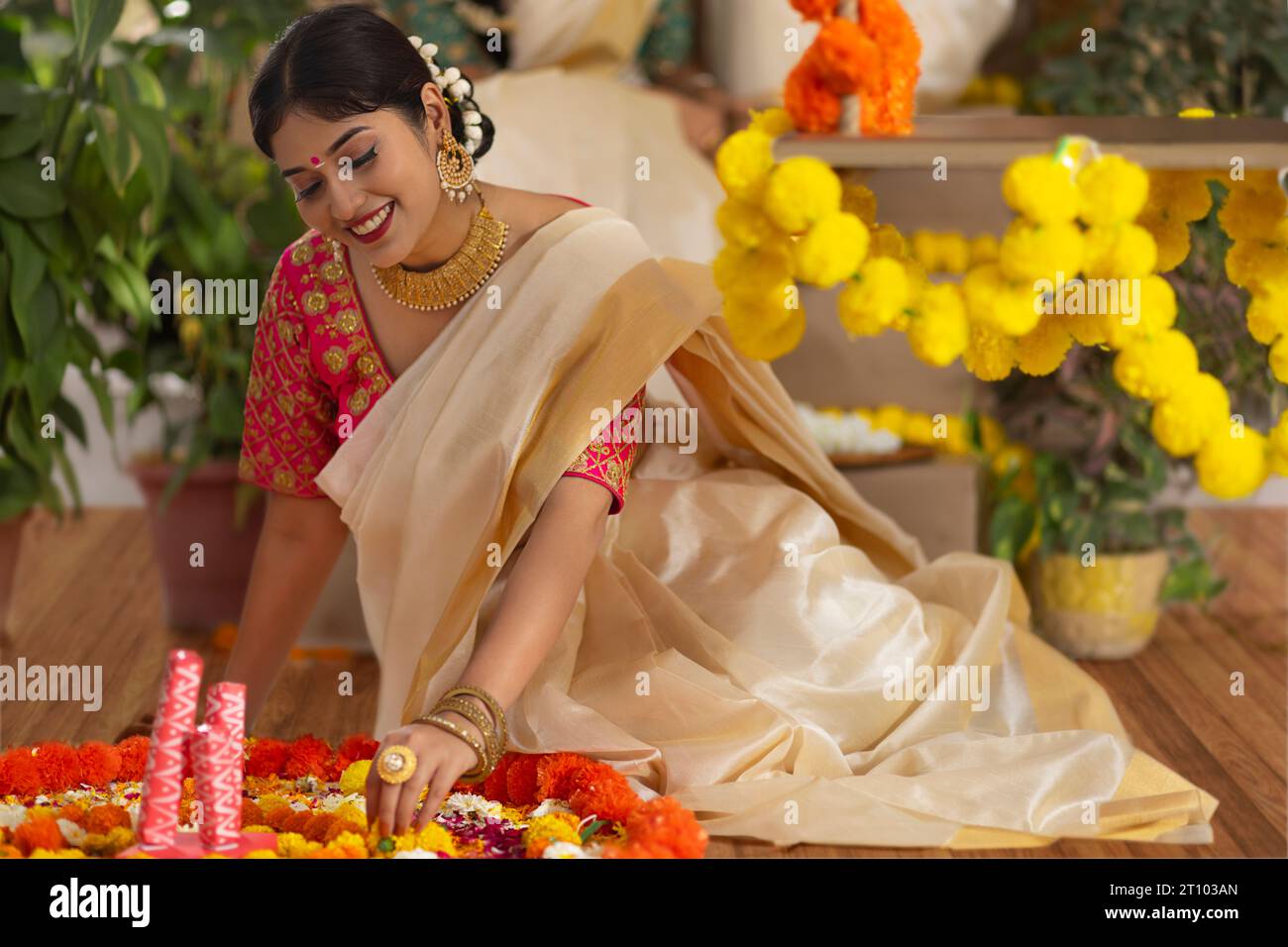 Frau, die den Boden mit Blumen aus Anlass von Onam dekoriert Stockfoto