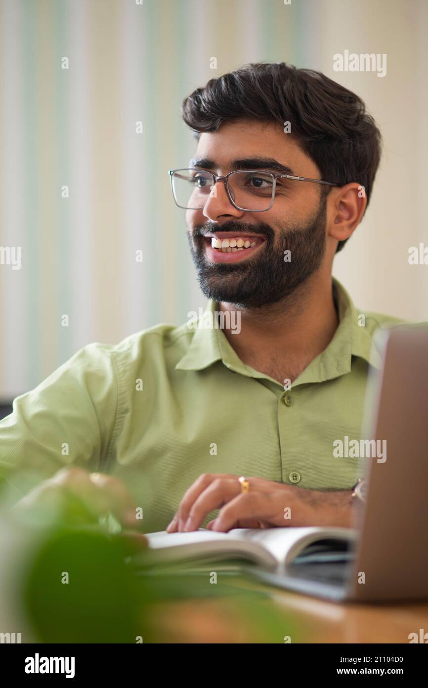 Nahporträt eines jungen Mannes, der in seinem Heimbüro arbeitet Stockfoto