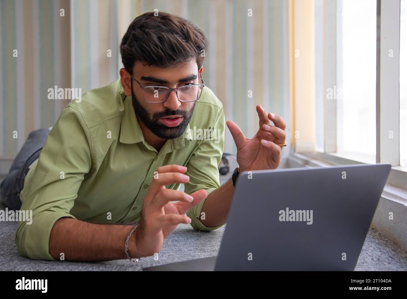 Junger Mann, der Videokonferenz auf Laptop hat Stockfoto